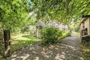 A wooden cabin with a gravel driveway and a wooden fence. - 3-bed Barn Eco-lodge on the Tarka Trail (Torrington)