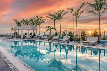 Una piscina al aire libre, sillones reclinables de piscina