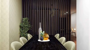 Un comedor moderno con una mesa de madera oscura, seis sillas, un jarrón con flores y un objeto de vidrio decorativo.