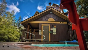 A lodge with a pool, wooden exterior, and a sign indicating 'No Fees on Duty'. - Incredible Views / Modern Updates / Hot Tub (Fernie)