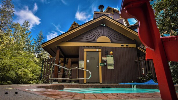 A lodge with a pool, wooden exterior, and a sign indicating 'No Fees on Duty'. - Incredible Views / Modern Updates / Hot Tub (Fernie)