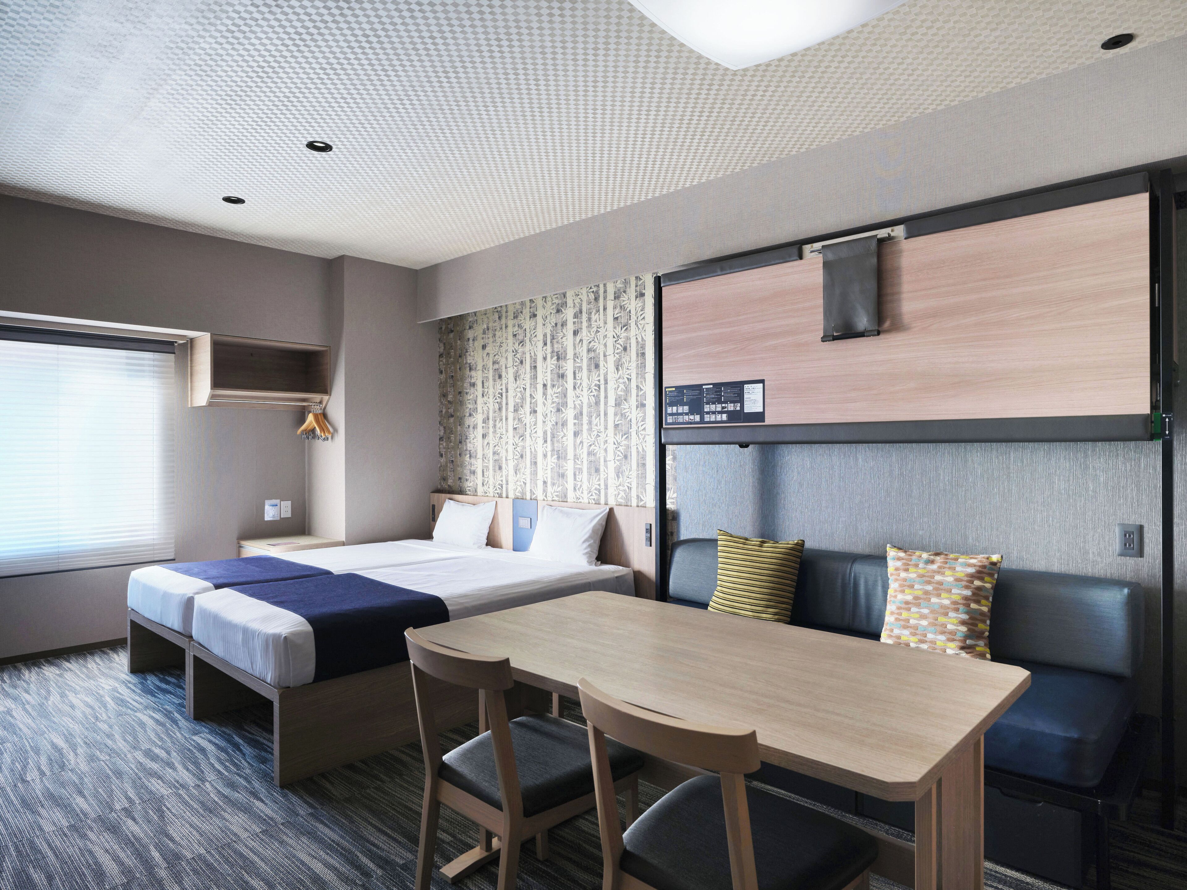 A hotel room with a bed, a desk, and a seating area.