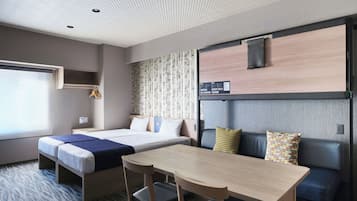 A hotel room with a bed, a desk, and a seating area.