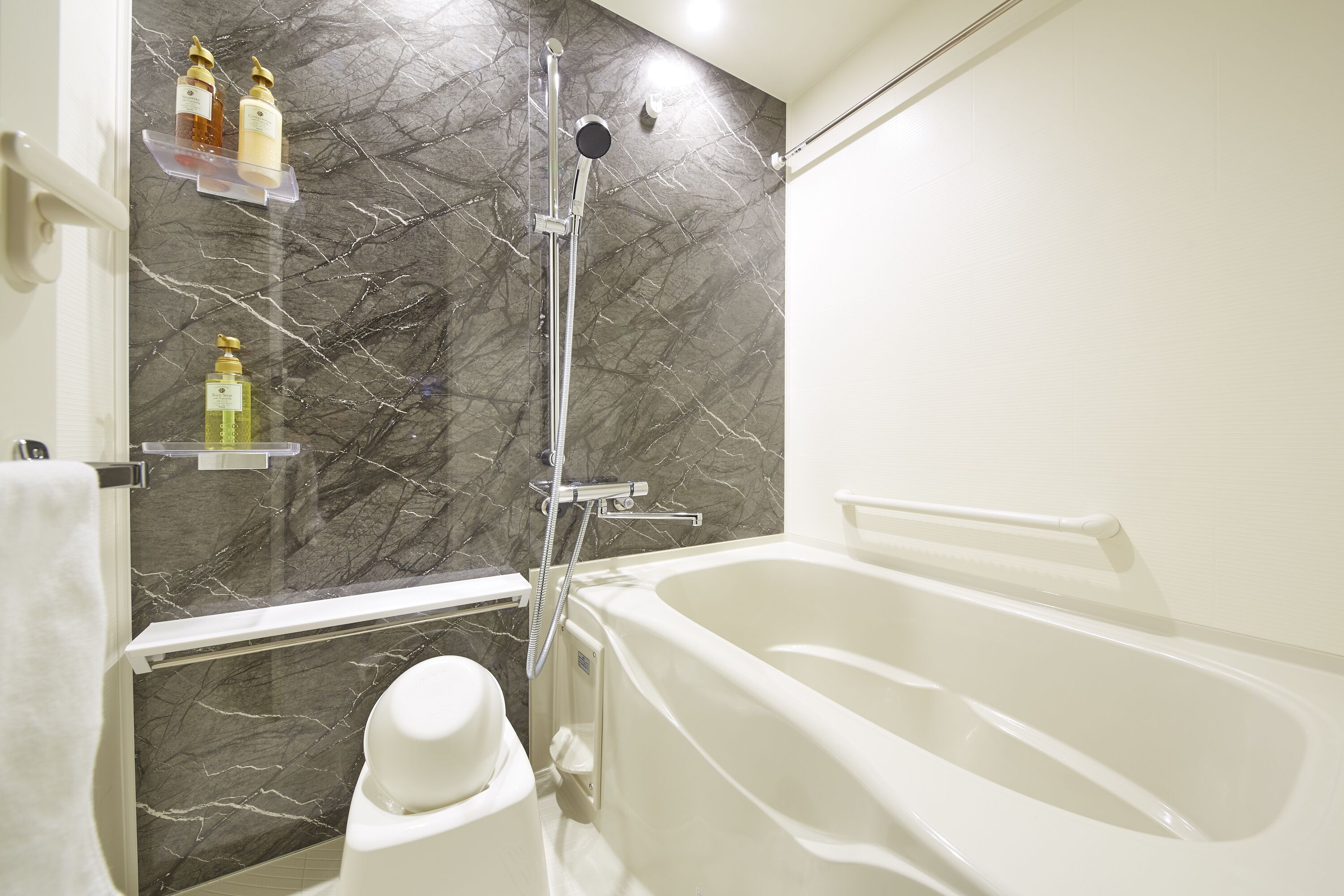 Un baño con bañera, ducha y paredes de mármol.