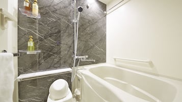 Un baño con bañera, ducha y paredes de mármol.