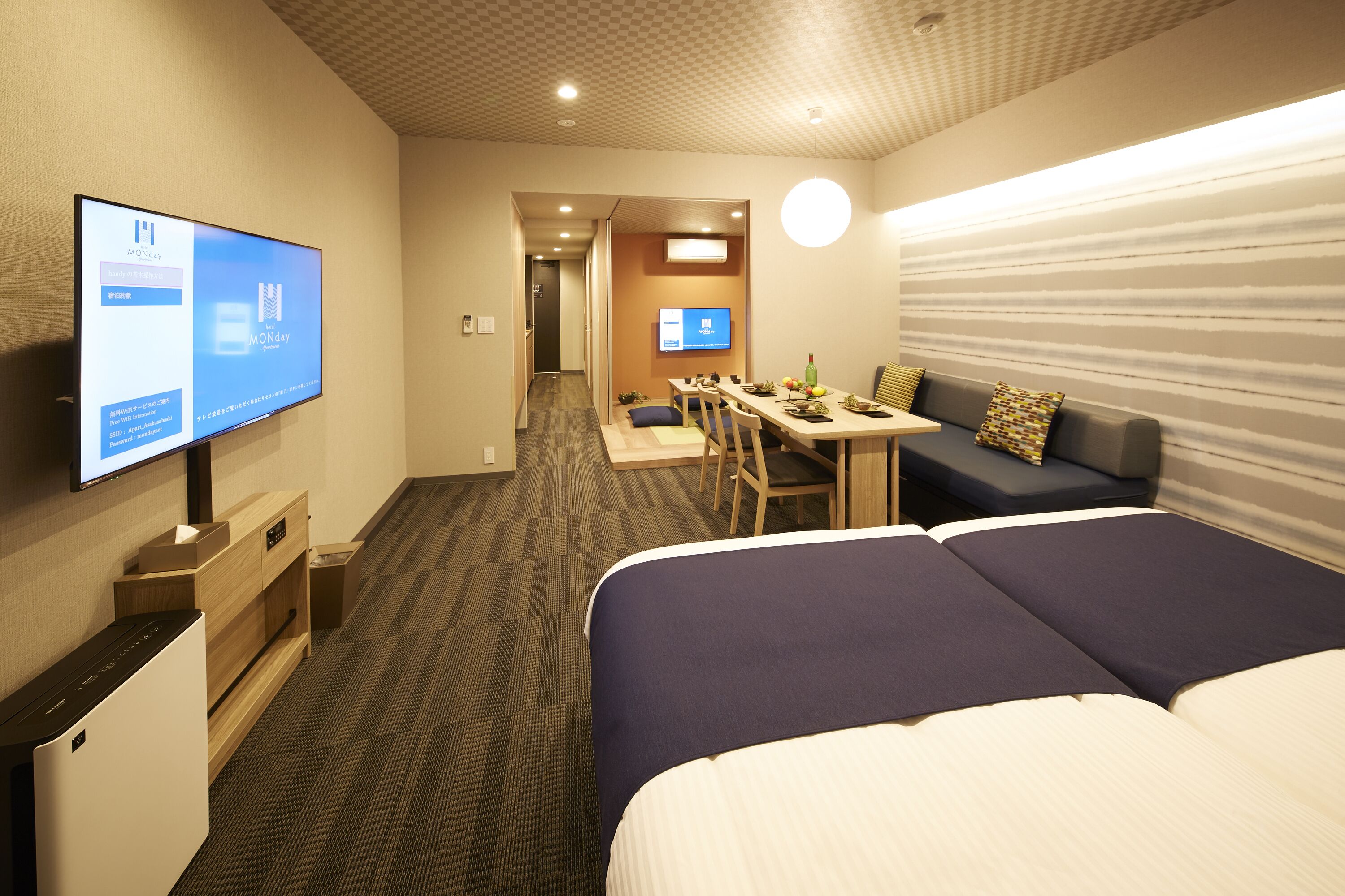 Une chambre d’hôtel avec un lit, un bureau, une télévision et un canapé.