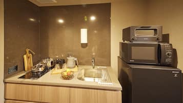 A modern kitchen with a built-in microwave, a sink, and a countertop with various kitchen items.