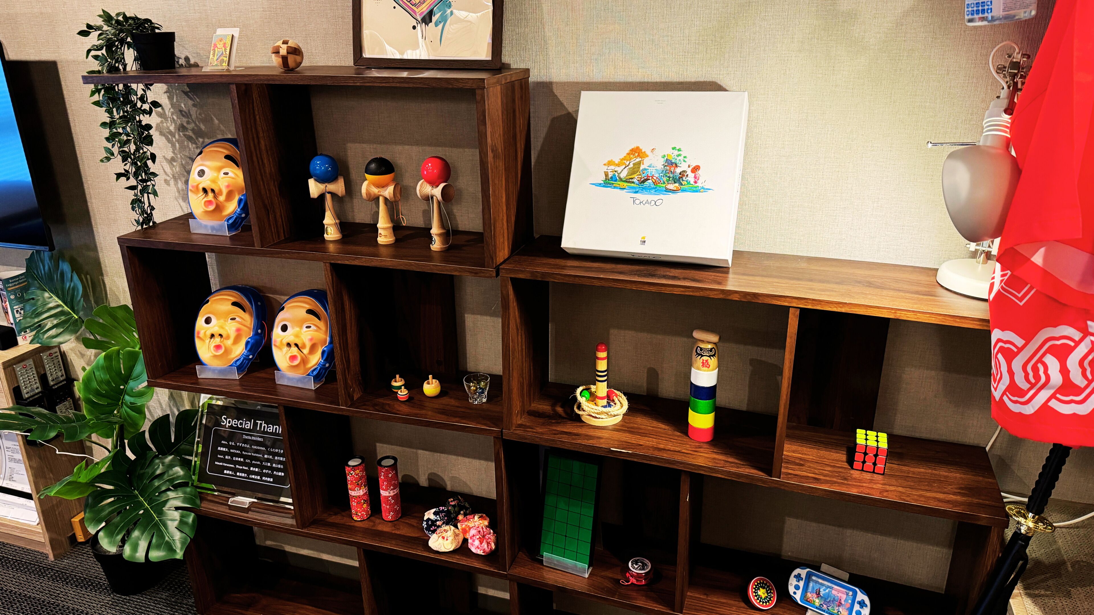 A wooden shelf with various items including a framed picture, a small plant, and decorative objects.