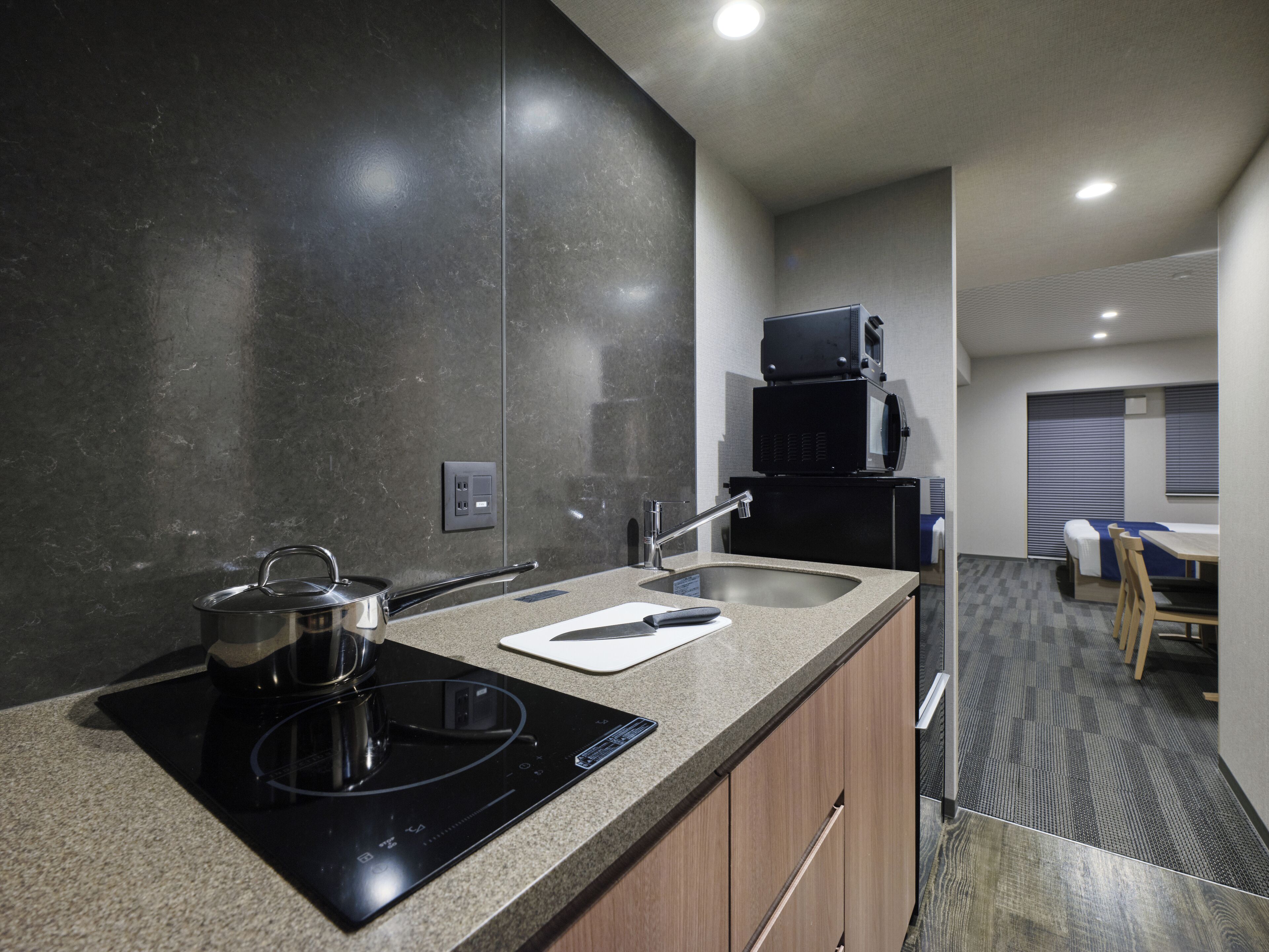 A modern kitchen with a built-in stove, sink, and a microwave.