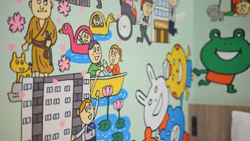 A wall with various cartoon characters and animals, a building illustration, and a bed with a wooden headboard.