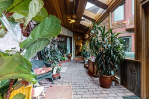 Relax in a serene outdoor space surrounded by lush greenery and a brick-paved walkway.