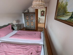 Une chambre à coucher avec un lit, une commode, un miroir et un tableau.