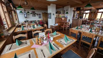 Ein Restaurant mit Holztischen, grünen Servietten und verschiedenen Gerichten.