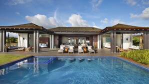 A poolside area with lounge chairs and a pool.