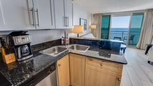 Eine moderne Küche mit Kaffeemaschine, zwei Spülen und Holzschränken.