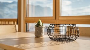 A wooden table with a wire basket and a small potted plant. - Welcoming Apartment "Eiche im Nockerhof" with Mountain View, Wi-Fi & Terrace (Andrian)