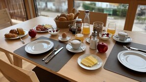 Una tavola imbandita per la colazione, con piatti, posate e diversi cibi.