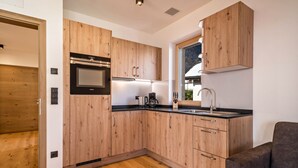 Una cucina moderna con mobili in legno, elettrodomestici in acciaio inossidabile e forno a incasso.