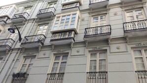 Un immeuble à plusieurs étages doté de balcons, de grandes fenêtres et de moulures décoratives.