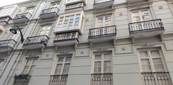A multi-story building with balconies, large windows, and decorative moldings.