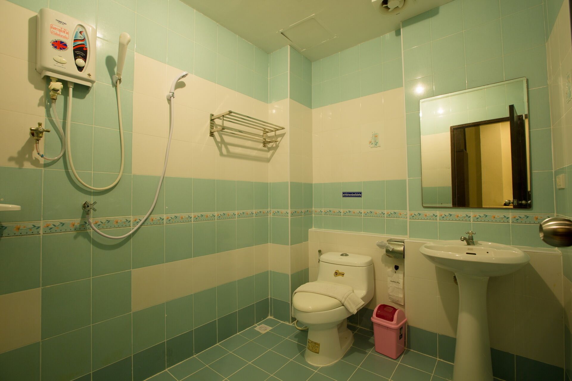 Une salle de bain avec des toilettes, un lavabo et une douche.