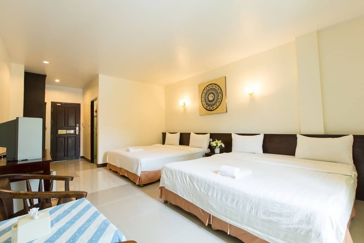 Une chambre d’hôtel avec deux lits, un bureau et une chaise.
