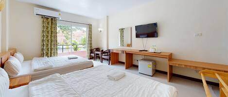 A hotel room with two beds, a desk, a television, and a window with curtains.