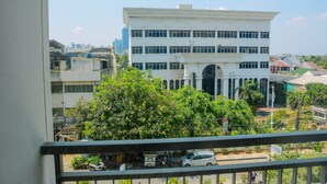 A multi-story building with a central arched entrance and a flat roof. - Modern and Tidy Studio Apartment at Elpis Residence (Jakarta)