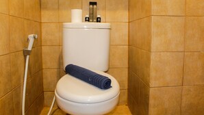 Ein Badezimmer mit Toilette, Handtuch und Toilettenpapierhalter.