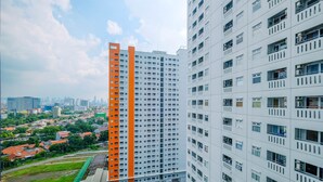 Um edifício residencial alto com várias varandas e uma estrutura com telhado verde adjacente.
