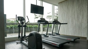 A gym with treadmills, an elliptical, and a stationary bike. - Spacious 2BR at Ciputra International Apartment (Jakarta)