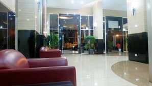 A modern lobby with a reception desk, seating area, and potted plants. - Modern and Comfort Stay @ Studio Pakubuwono Terrace Apartment (Jakarta)