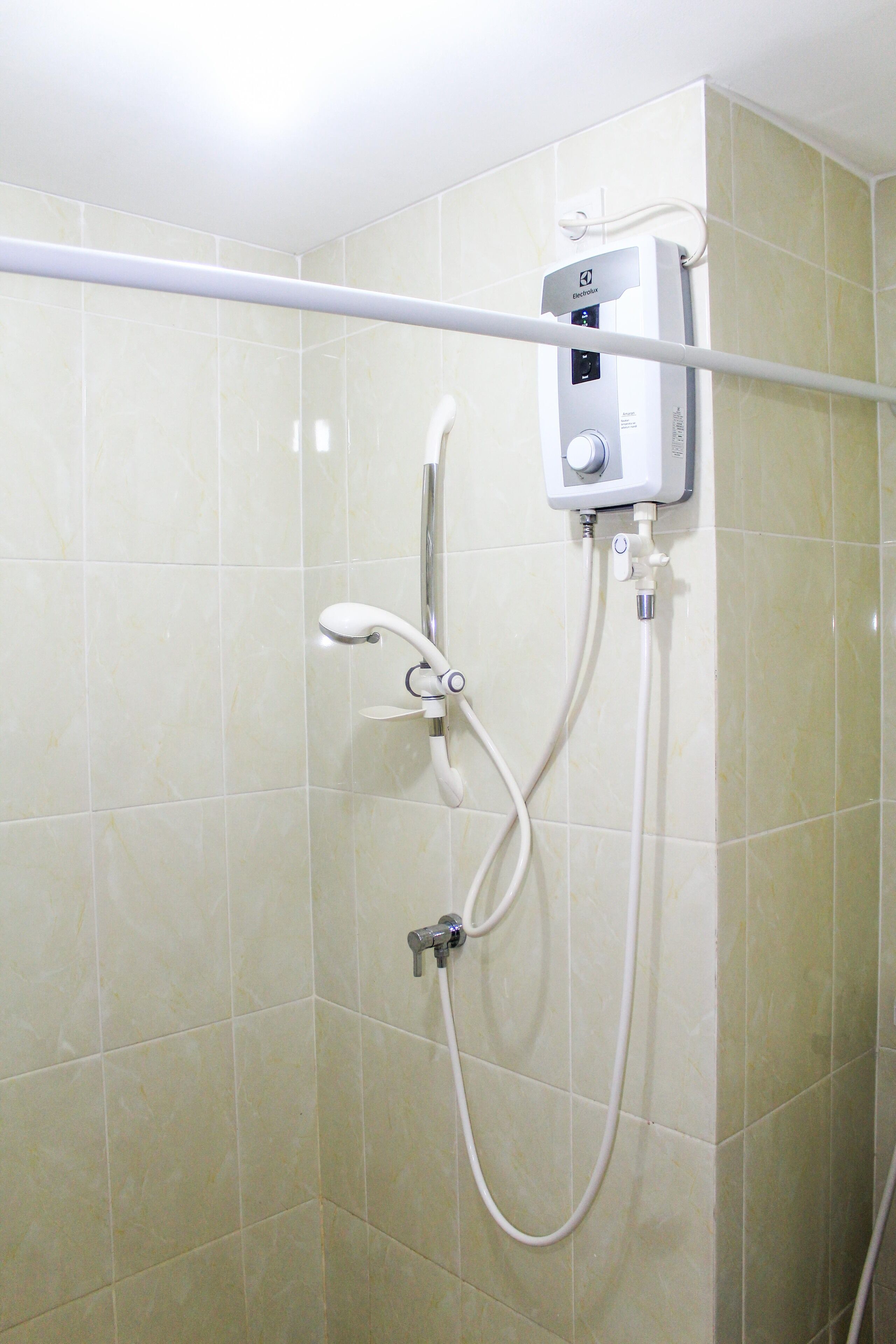 A shower with a handheld showerhead and a wall-mounted control panel.