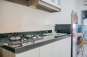 Una cocina moderna con estufa a gas, un lavamanos y un refrigerador.