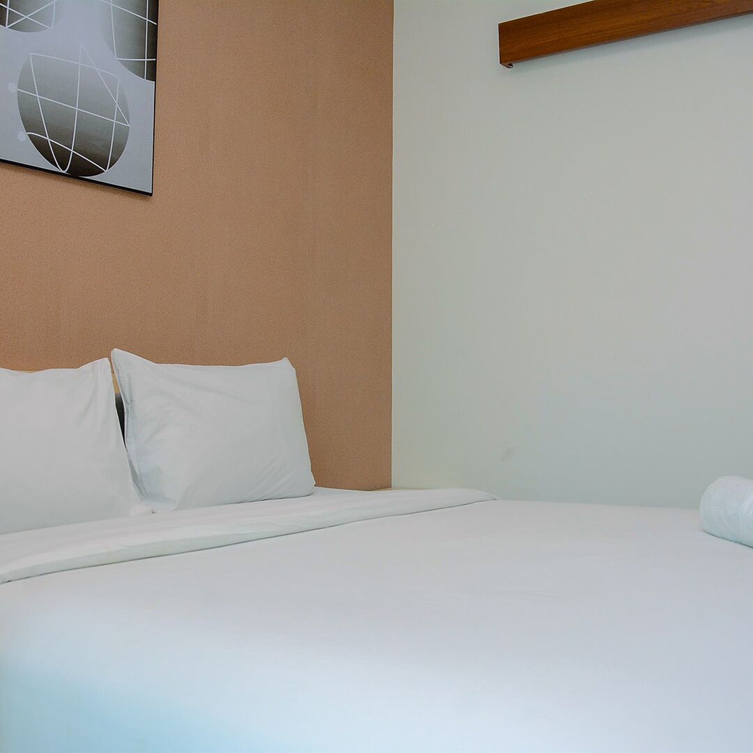 A neatly made bed with white bedding in a room with a beige wall and a modern abstract painting.
