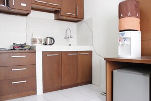 Compact kitchen with sink, refrigerator, and stove.
