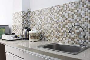 Fridge, stovetop, cookware/dishes/utensils - Comfy Studio Apartment at Emerald Tower (Bandung)