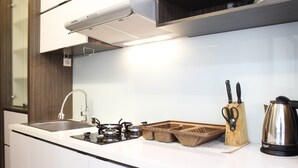 Uma cozinha moderna com pia de aço inoxidável, fogão a gás e tábua de corte de madeira.