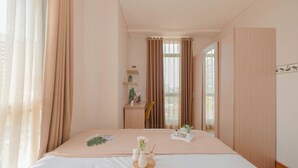 Un dormitorio ordenado con cama, mesita de noche y una pequeña estantería con objetos decorativos.