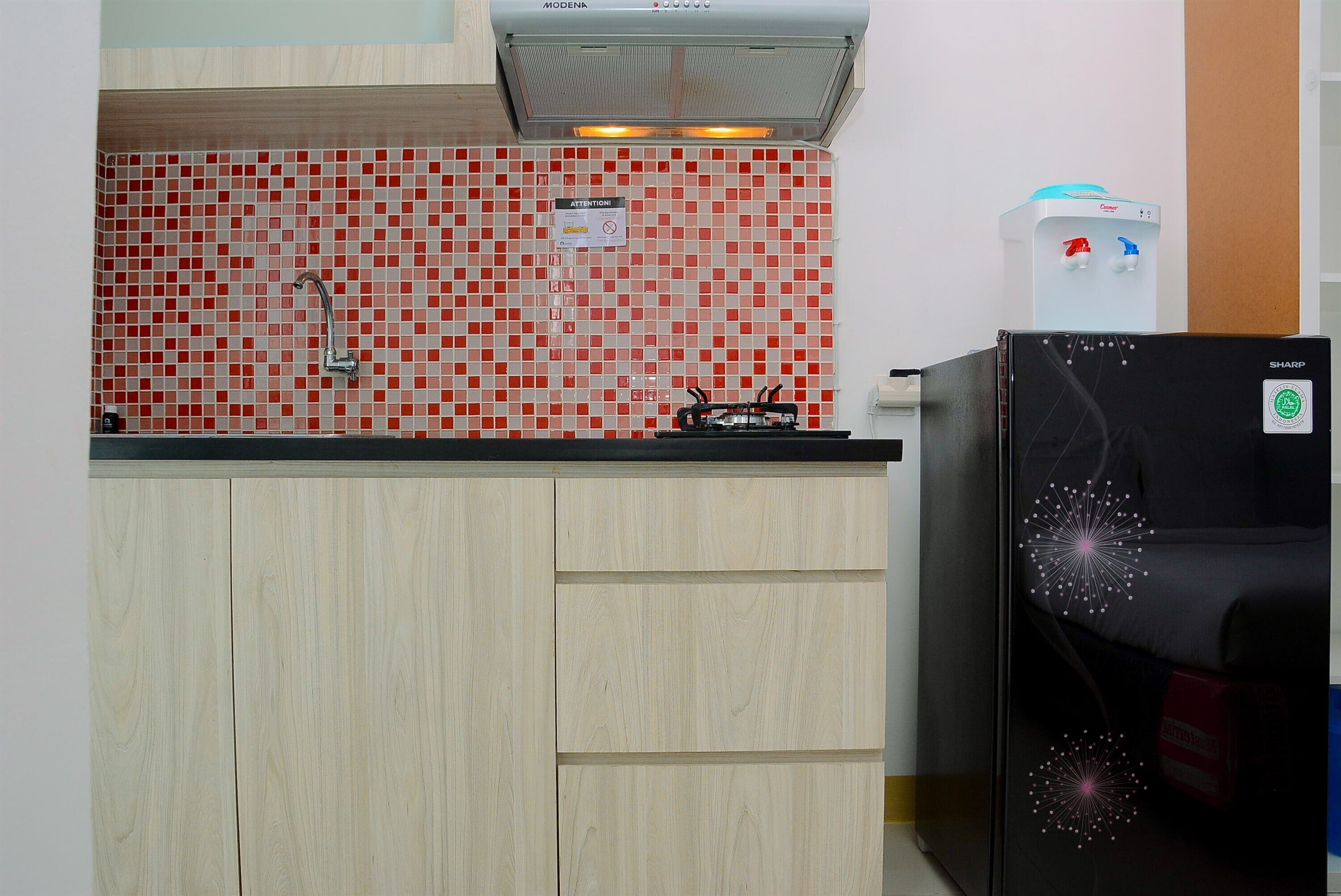 A kitchen with a tiled backsplash, a built-in stove, and a refrigerator.