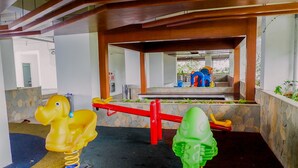 A children's play area with a seesaw and two animal-shaped swings. - 1BR Fully Furnished Bassura City Apartment (Jakarta)