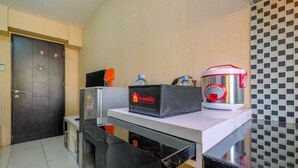 Una kitchenette equipada con refrigerador, microondas, cafetera y dispensador de agua.