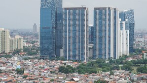 A high-rise building with a modern glass facade, surrounded by a dense urban area with smaller residential buildings. - Amazing 1BR Apartment at The Wave @ Rasuna Epicentrum (Jakarta)
