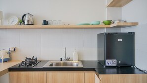 Eine moderne Küche mit Gasherd, Edelstahl-Spüle und einem schwarzen Kühlschrank.