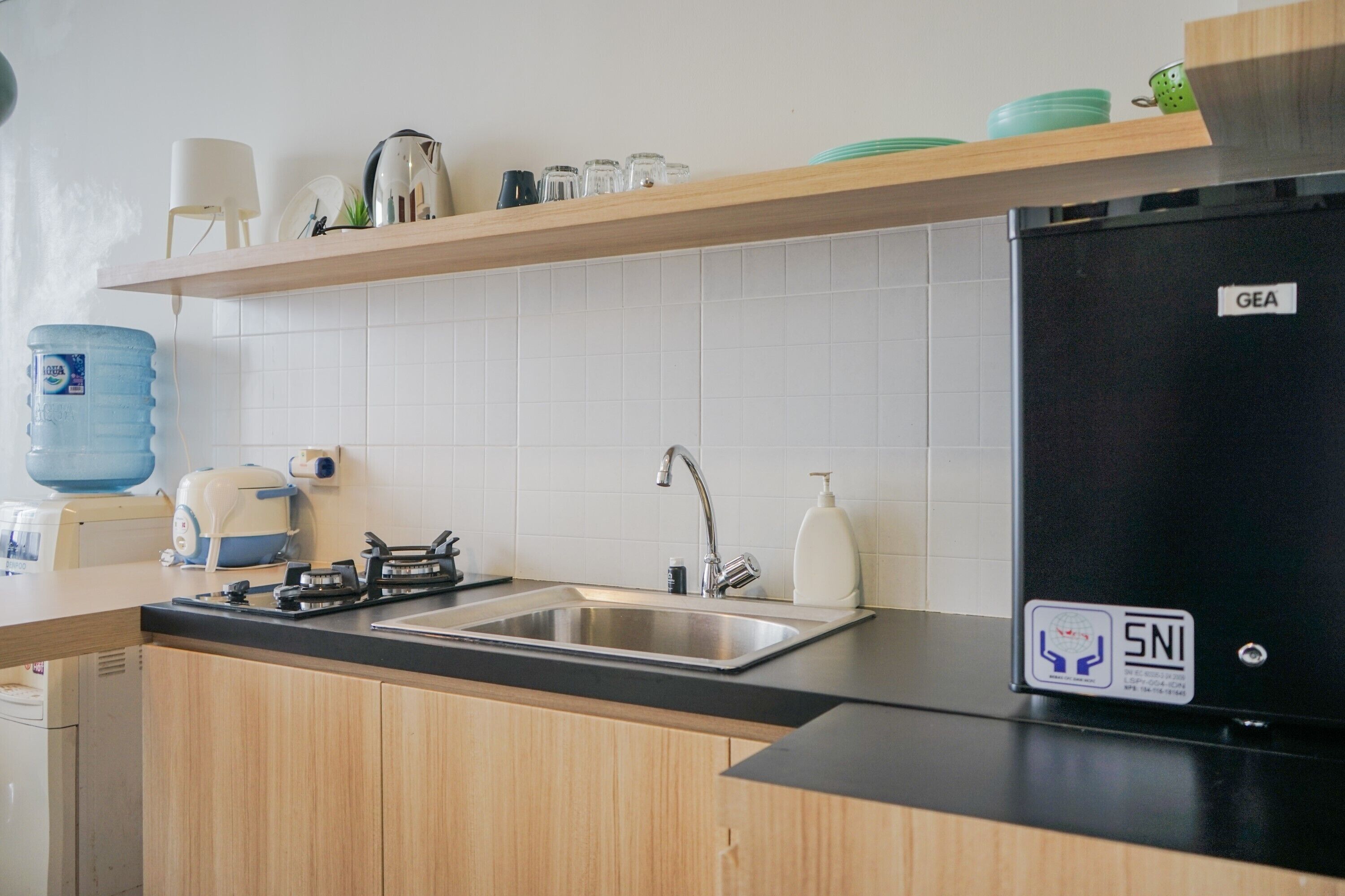 Una cocina con un lavamanos, estufa y un refrigerador GEA.