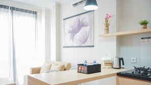 Eine moderne Küche mit Essbereich, einer Kaffeemaschine und einem Wasserkocher auf der Arbeitsfläche.