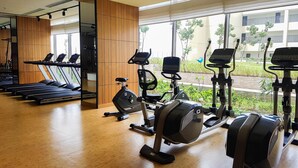 A gym with treadmills, stationary bikes, and a mirrored wall. - Lavish and Pleasant 2BR Apartment at The Branz BSD (Pagedangan)