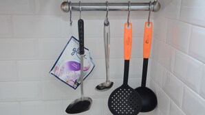 Una cucina con un appendiabiti che contiene diversi utensili.