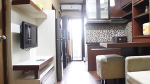 Cozinha compacta com geladeira, micro-ondas e um balcão pequeno.