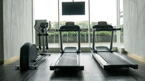 Una palestra con tapis roulant, una cyclette e uno schermo televisivo.